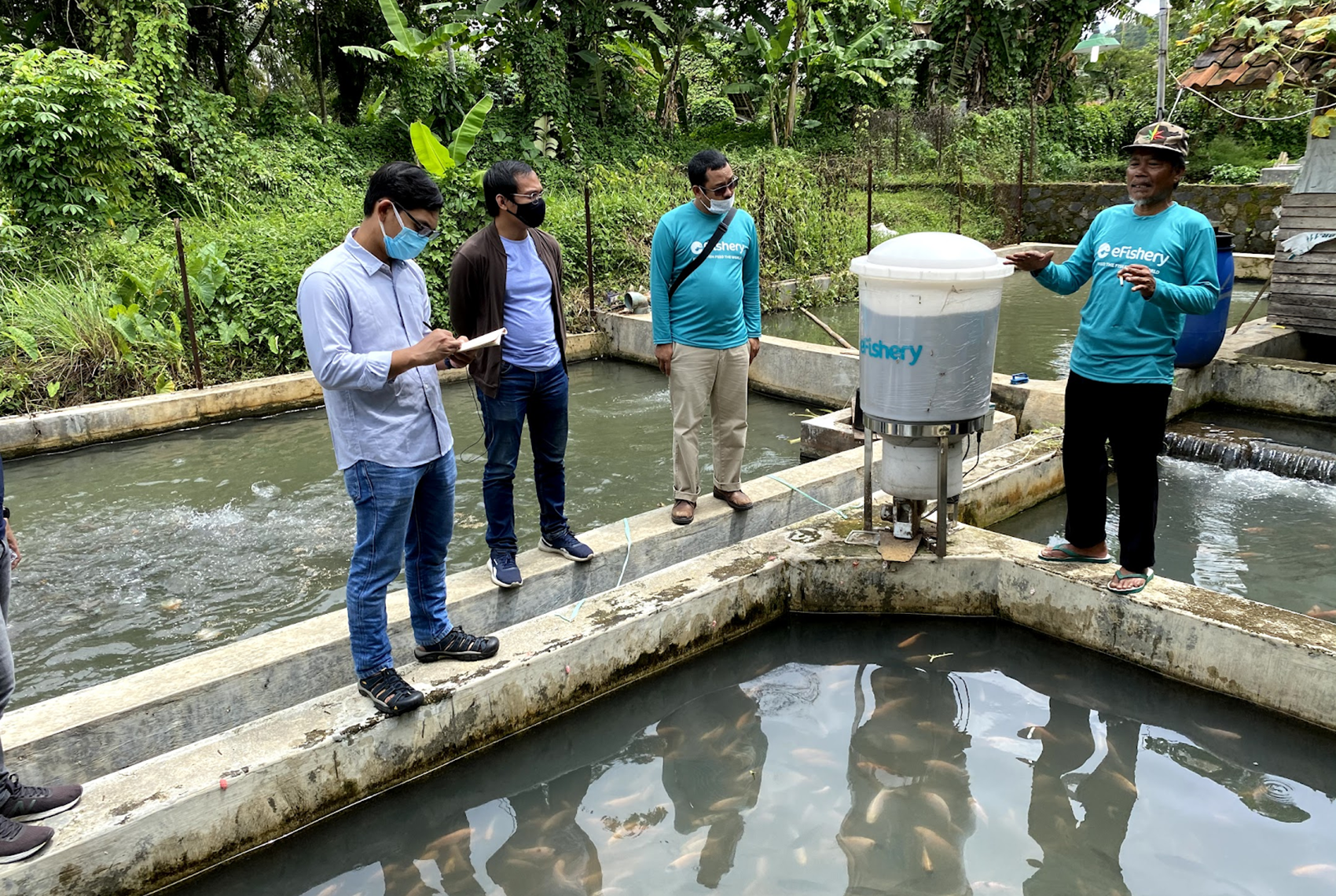 Aldi with Gibran Huzaifah, CEO and Cofounder of eFishery, learning from a fish farmer about how the robot feeder helps increase his income.